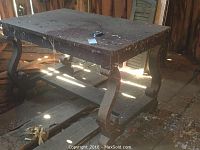 View of table showing overall shape, carved scroll legs and stretcher support