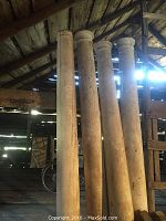 Front view of four columns leaning indoors under roof rafters