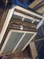 Stack of vintage wooden windows with white peeling paint and glass panes, showing multiple sizes interspersed