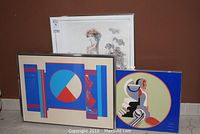 Three signed and numbered artworks shown. Blue Assembled Image print by Bud Hopkins (framed) in front, A. Belkin Untitled print in clear sleeve behind, and one framed poster with circular figures to the right.