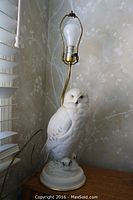 Snowy owl base lamp close-up showing detailed porcelain owl figurine and lamp socket.