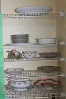 Five shelves with assorted white and decorative serveware including stack of plates, bowls and platters