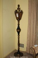 Full view of the entire brass torchiere floor lamp showing its height and base details.