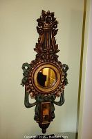 Full front view of the French style giltwood wall mirror showing the ornate lyre cresting, round mirror, and detailed carved elements with gilt and green finishes.