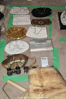 Collection of nine vintage beaded purses, two pairs of opera glasses, and a mink collar wrap all displayed on the floor.
