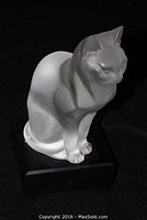 Front view of frosted glass cat figurine seated on black base
