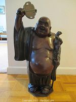 Front view of full bronze Hotei figure on hexagonal base, holding fan and staff