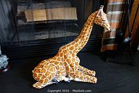 Seated giraffe figurine on hearth, front-left view