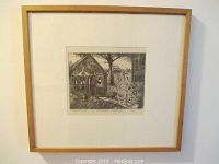 Framed engraving visible on a wall showing entire piece with wooden frame and white mat.