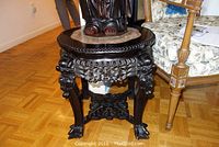 Front-angle view of table showing marble inset and carved apron beneath top.