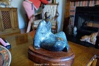 Front-right angle view showing seated figure and base