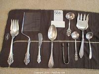 Overview of eight Wallace sterling utensils displayed on cloth