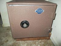 Overall view of brown Hercules fire-resistant safe with combination dial and metal door.