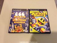 Two PlayStation 2 game cases: 'Shrek Eggstreme Madness' and 'Pac-Man World 3'