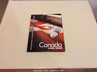 Photo of the front cover of the Canada 1999/2000 millennium 25 cent coins booklet with images of coins and Canadian flag design.