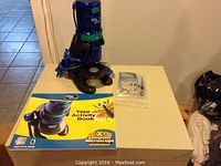 Blue Digital Blue CX3+ computer microscope, activity book, and plastic bag with microscope slides on a small table.