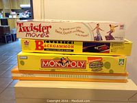 Stack of four board games including Twister Moves, Strategies Backgammon, SpongeBob Monopoly, and Jomar Real Estate Agent game visible in the first photo.
