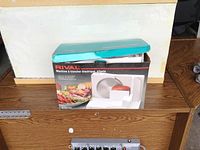 Rival electric food slicer in original box with product image and branding.