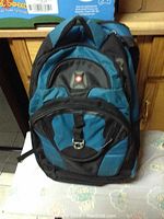 Front view of blue and black children's backpack showing multiple compartments and clasp