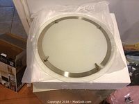 Top view of the round ceiling light fixture showing frosted glass cover and metal frame.