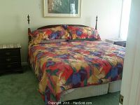 Full view of bed assembled with colorful bedspread showing size and overall appearance
