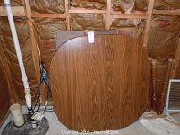 Photo of wooden dining table top and two extension leaves showing wood grain finish and size reference.
