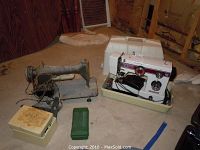 Two sewing machines shown: White brand with carrying case on right, vintage unmarked metal machine on left.