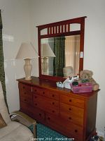 Full view of Vaughan wood dresser with attached mirror, showing the dresser top with items and mirror reflection.