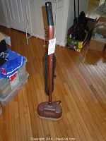 Full view of the Westinghouse electric floor buffer standing upright on a hardwood floor with visible dust and wear.