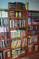 Three wooden shelves filled with a variety of children's books in hardcover and paperback format, arranged vertically and horizontally.