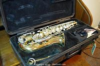 Bundy II alto saxophone laid in black hard case with plush interior, includes mouthpiece and cleaning accessories.