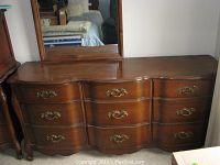 Front view of wooden dresser with attached mirror showing overall condition and details.