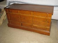 Side view of wooden cedar chest showing panel design and wood grain.