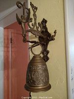 Full view of the cast bronze bell and wall mount bracket hung on wall