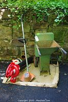 Photo showing the full lot including the green metal Lindig soil shredder chipper, red Troy Built leaf blower/vacuum, and Black & Decker weedwacker, all sitting on cardboard