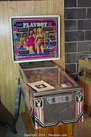 Full front view of Bally Playboy pinball machine with detached legs leaning beside it