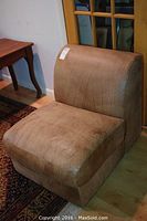 Front and side view of the brown leather armless side chair showing overall condition and upholstery texture.