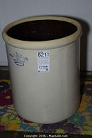 10 gallon crock with blue crown and number 10 on front, standing on colorful rug