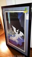 Angled view of entire framed serigraph showing artwork and black wooden frame under glass