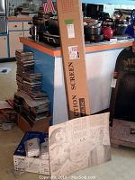 Wide view showing projector box, projection screen box, artwork panel and stacked CDs (CDs not included)