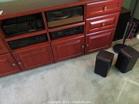 Red wood console with four audio components installed and four speakers on floor