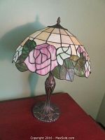 Front view of table lamp showing full metal base and stained glass style mosaic resin shade with pink roses and green leaves.