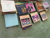 A group photo of the collection of multiple vinyl record albums arranged on floor, showing about 11 albums with different covers and sleeves.