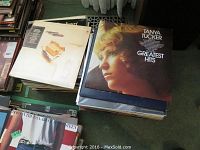 Stacks of vinyl record albums including Tanya Tucker Greatest Hits on top