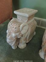 Full view of the ceramic elephant garden stool on carpet showing overall form and design