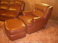 Brown leather armchair and matching ottoman shown together, highlighting color and finish.