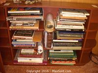 Books on shelves showing various titles including Complete Atlas of the World, Creative Art Crafts, Our National Parks, Page One, and others.