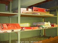 Shelf view showing assorted boxed board games including multiple Monopoly boxes, ACTION game and other titles