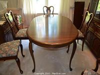 Oval mahogany tabletop with cabriole leg visible at front