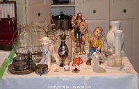 Wide view of assorted glassware, ceramics, figurines, and silver plate items on table.